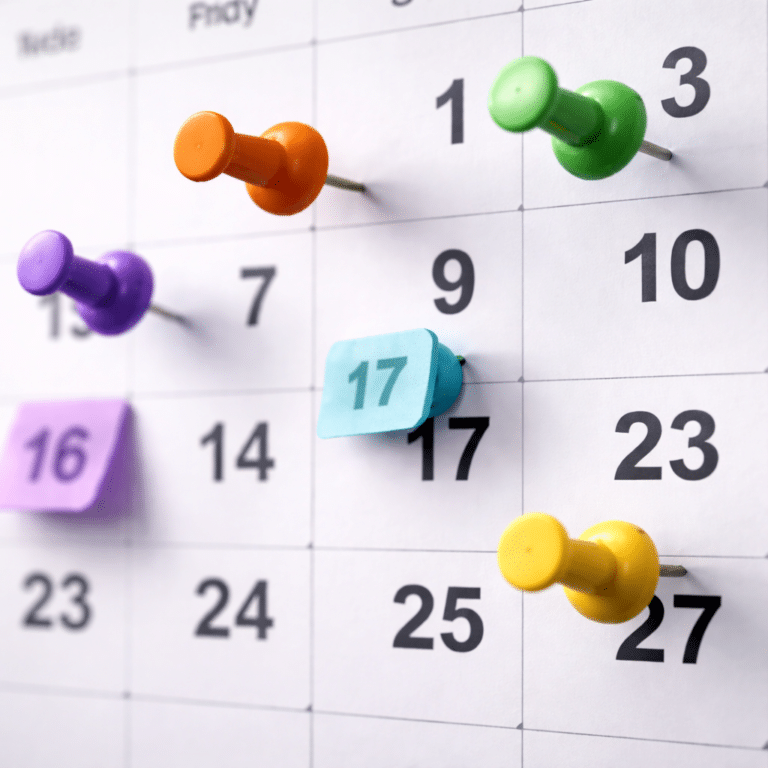 Calendrier mensuel avec punaises colorées pour planification et organisation des tâches