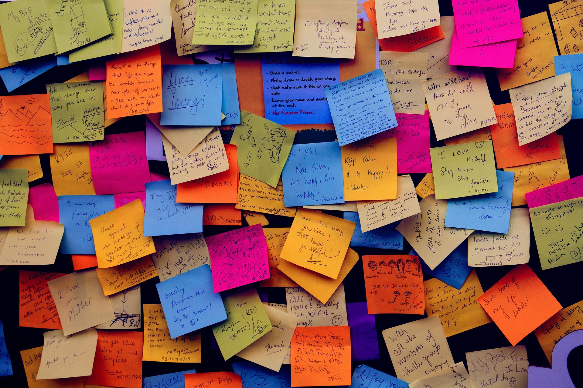 mur rempli de post-it colorés avec des notes et idées écrites