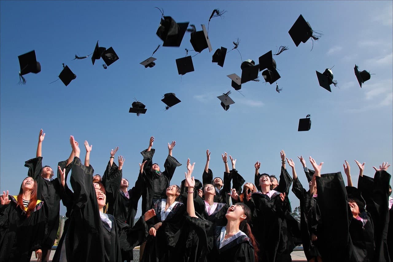 Jeunes étudiants célébrants la remise des diplômes en lançant leurs chapeaux.